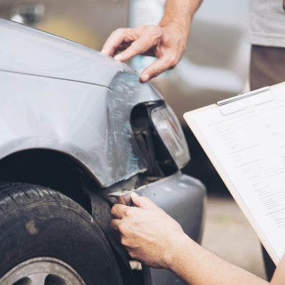 Insurance agent working during on site car accident claim process - people and car insurance claim concept